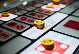 Dealer profesional jnt77 membagikan kartu di meja Lucky Twins